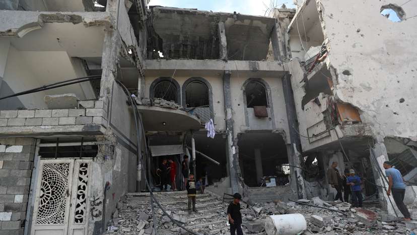 Palestinians inspect the site of an Israeli airstrike on a medical clinic, in Jabalia