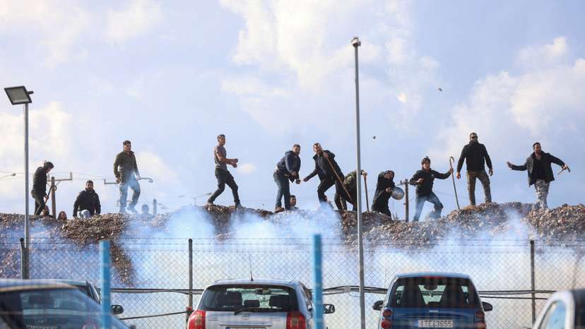Greek farmers hurl stones amid tear gas at the Heraklion International Airport, in Heraklion