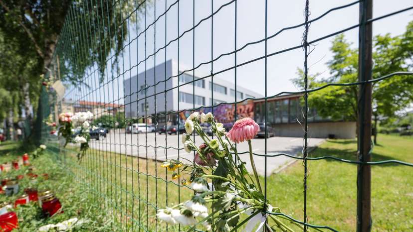 Flowers and candles are seen in front of the fences of the school in Graz