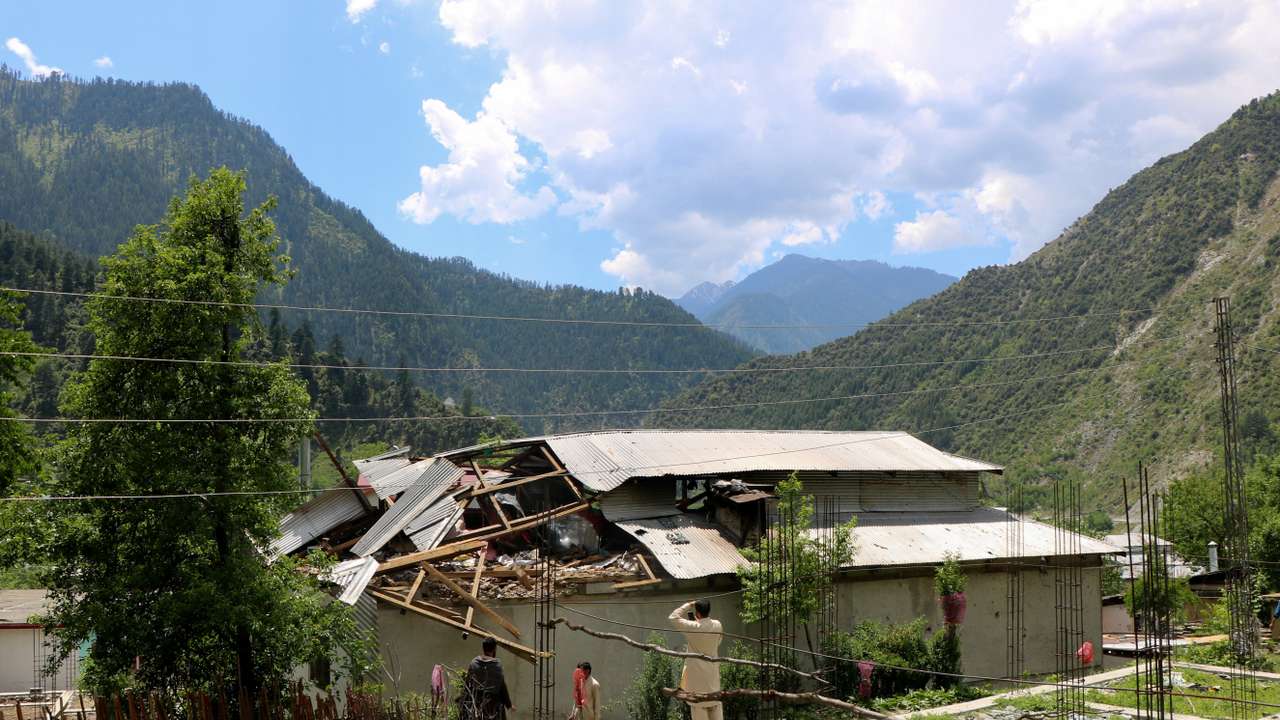 Residents inspect damage to a house after it was hit by an Indian strike in Shahkot Village, in Neelum Valley