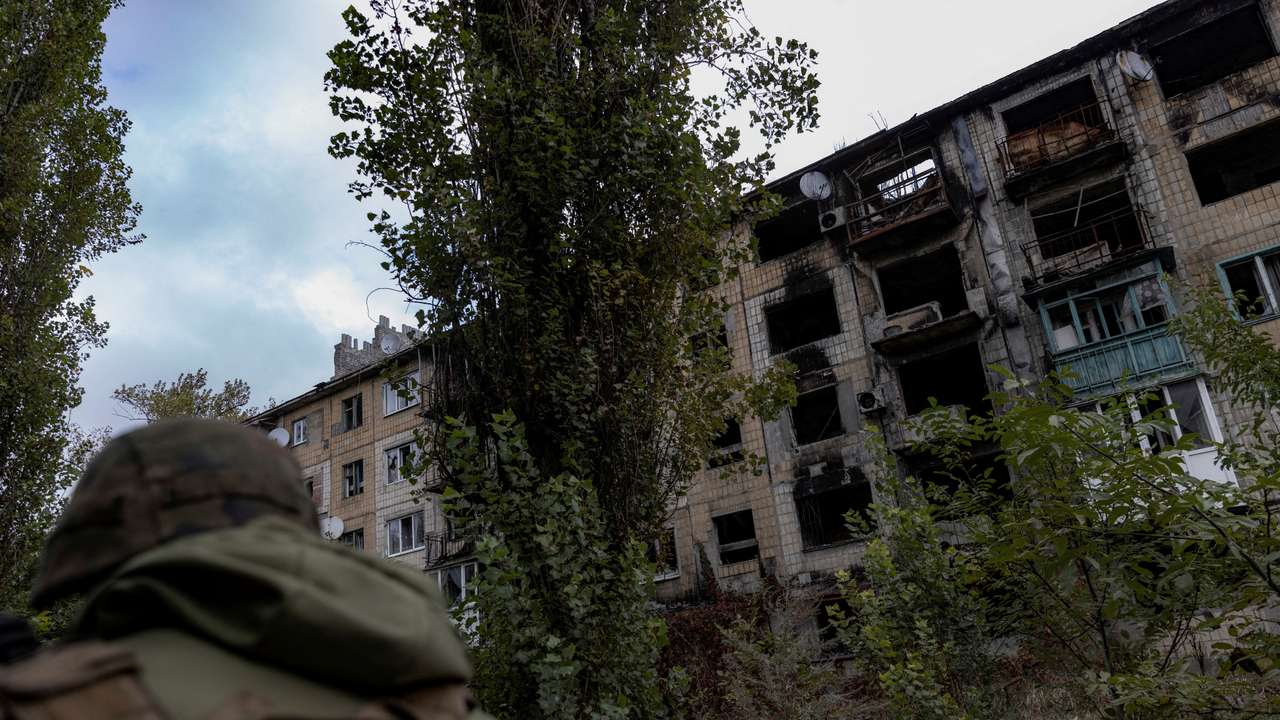 FILE PHOTO: Police officer walks near a damaged residential building in Avdiivka