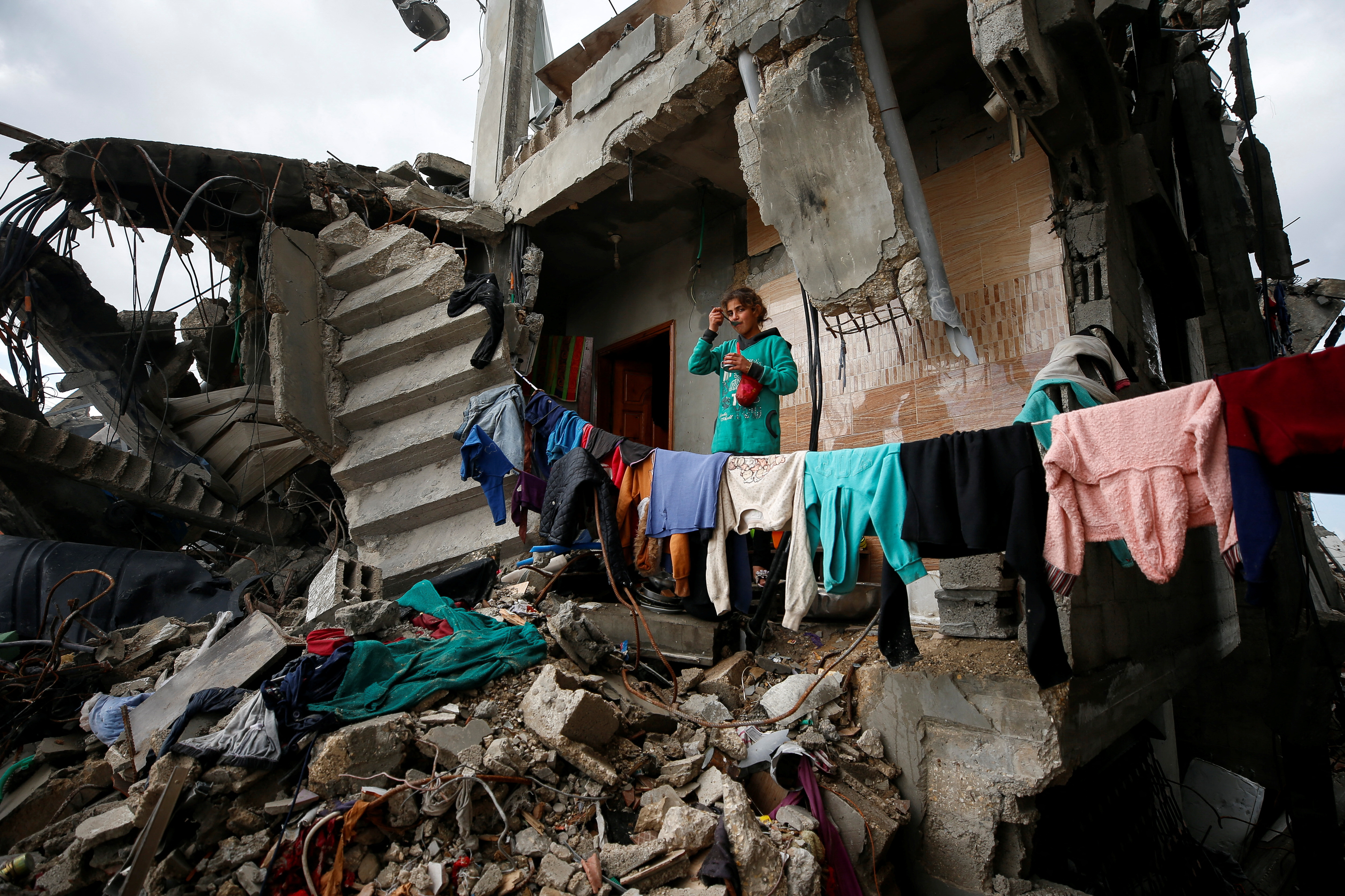 A Palestinian girl stands at the remains of her family's destroyed house where she takes shelter, amid a ceasefire between Israel and Hamas, in Jabalia refugee camp in the northern Gaza Strip