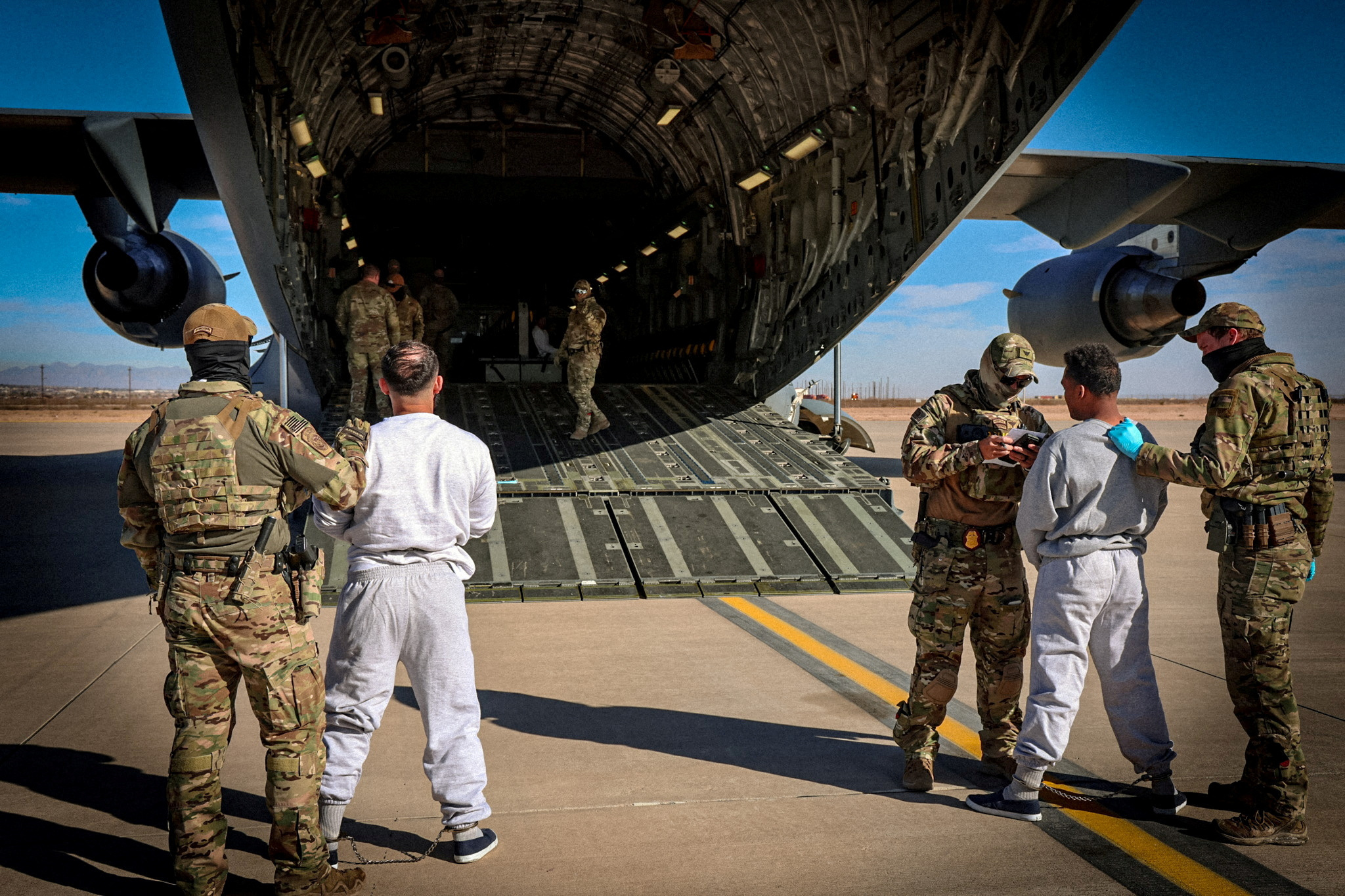 FILE PHOTO: The first U.S. military aircraft to carry detained migrants to Guantanamo Bay is boarded from an unspecified location in the U.S.