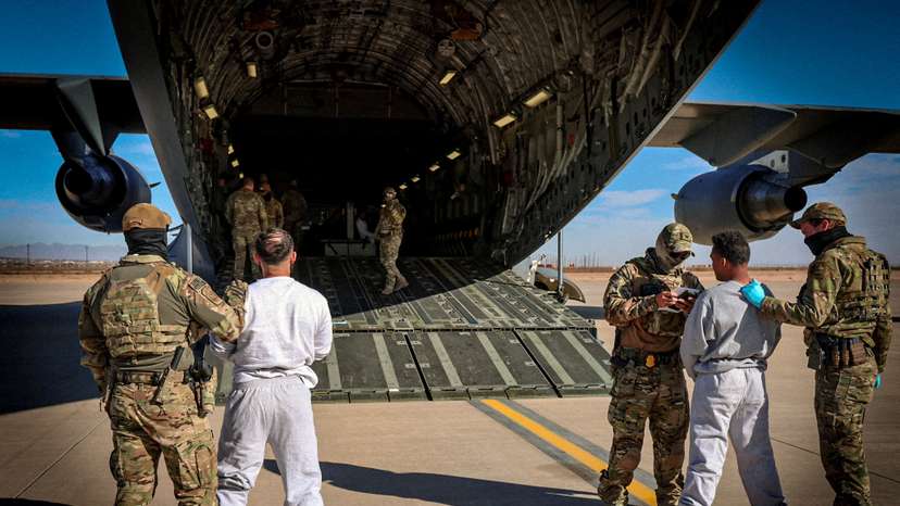 FILE PHOTO: The first U.S. military aircraft to carry detained migrants to Guantanamo Bay is boarded from an unspecified location in the U.S.