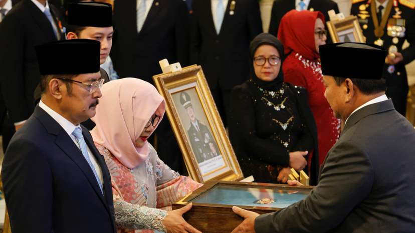 Indonesia's President Prabowo Subianto gives a plaque to Siti Hardiyanti Rukmana, daughter of the former Indonesian president Suharto, as he receives the title of a national hero during National Heroes' Day at the Merdeka Palace in Jakarta