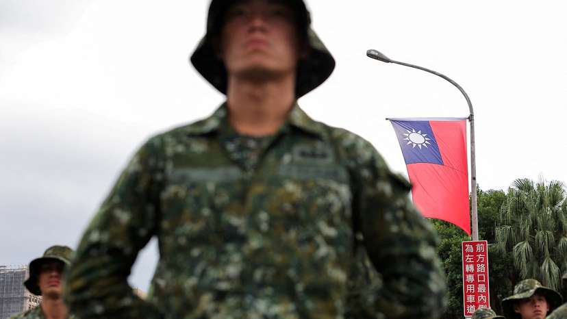 A Taiwan flag flutters in the wind as soldiers prepare to celebrate national day to mark the 113th birthday of the Republic of China