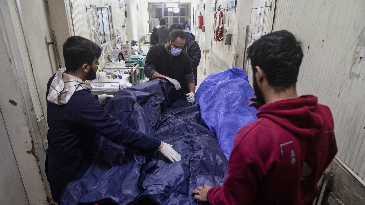 Paramedics place a body into a body bag at a hospital in Aleppo