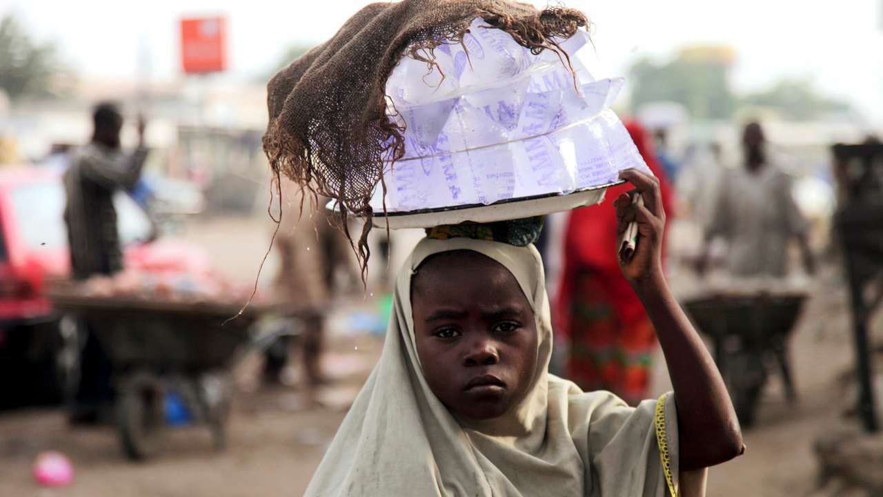 Girl hawks drinking water packed in sachets along a street after days of religious clashes in the northern Nigerian city of Maiduguri