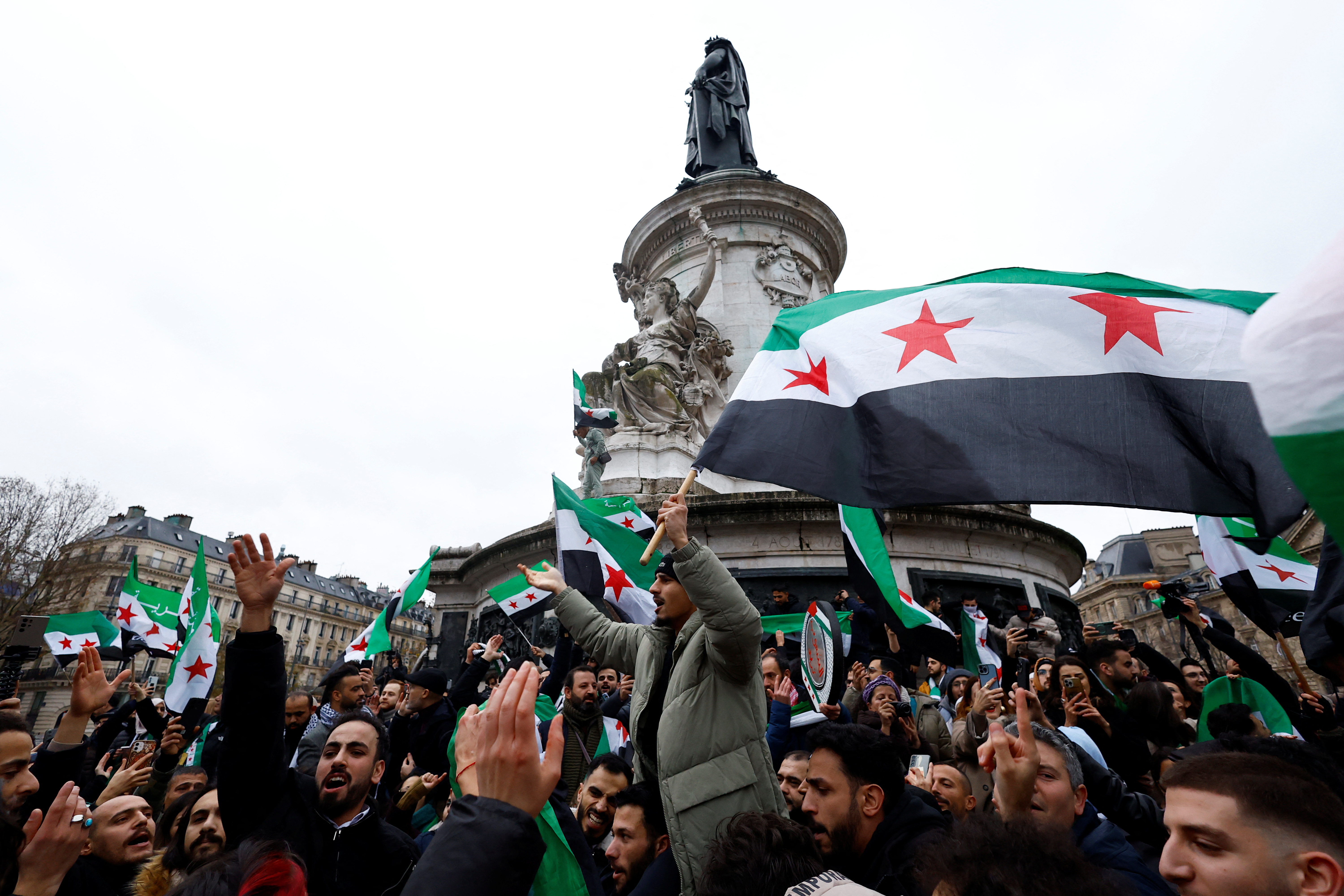 People gather in Paris, after Syrian rebels announced that they have ousted President Bashar al-Assad