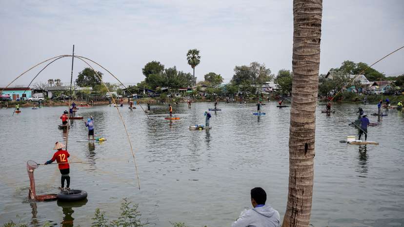FILE PHOTO: People fish in a pond on the outskirts of Buriram province