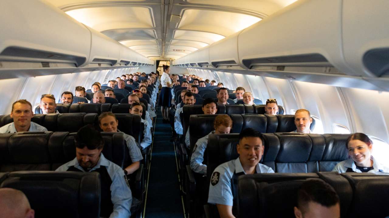 Members of the Australian Federal Police board a flight to the Solomon Islands in Australia
