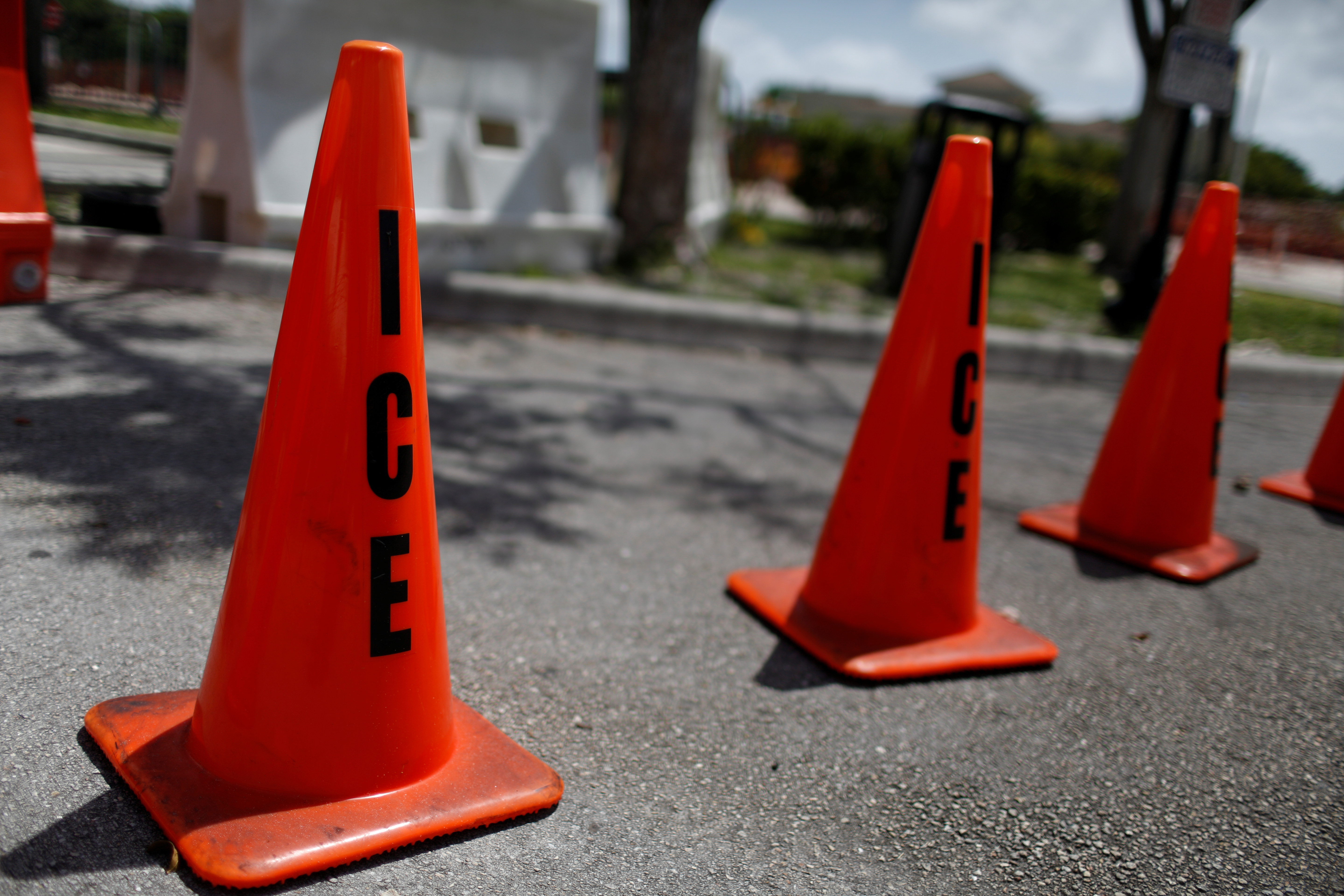 Orange traffic cones with the word "ICE" are seen at ICE facilities