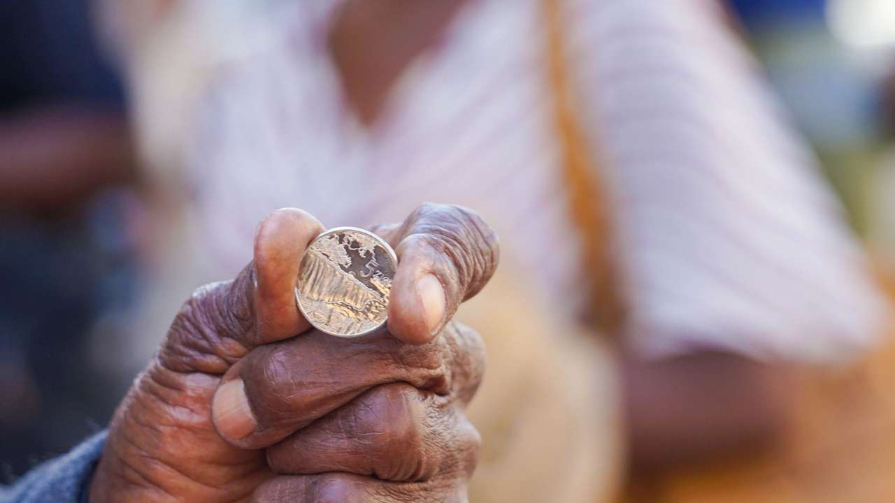 A man holds a ZiG coin, part of Zimbabwe's sixth currency since independence in 1980.