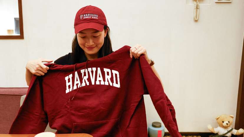 Yu-Hsuan Lin poses for a photo with a Harvard hat and hoodie in Taipei