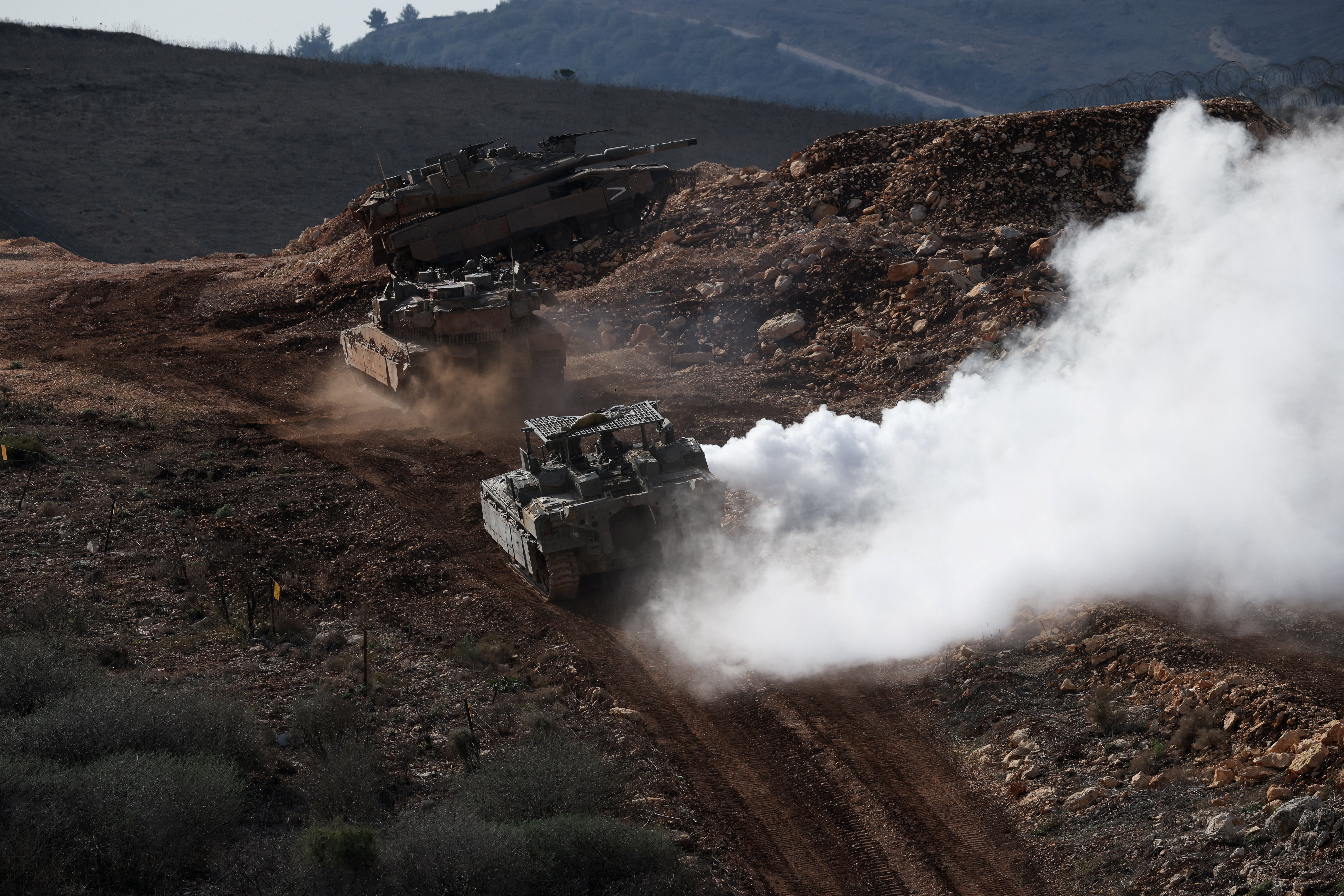 Israeli military vehicles manoeuvre along the Israel-Lebanon border as seen from northern Israel