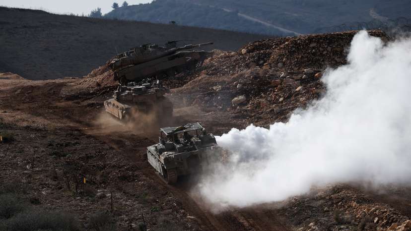 Israeli military vehicles manoeuvre along the Israel-Lebanon border as seen from northern Israel