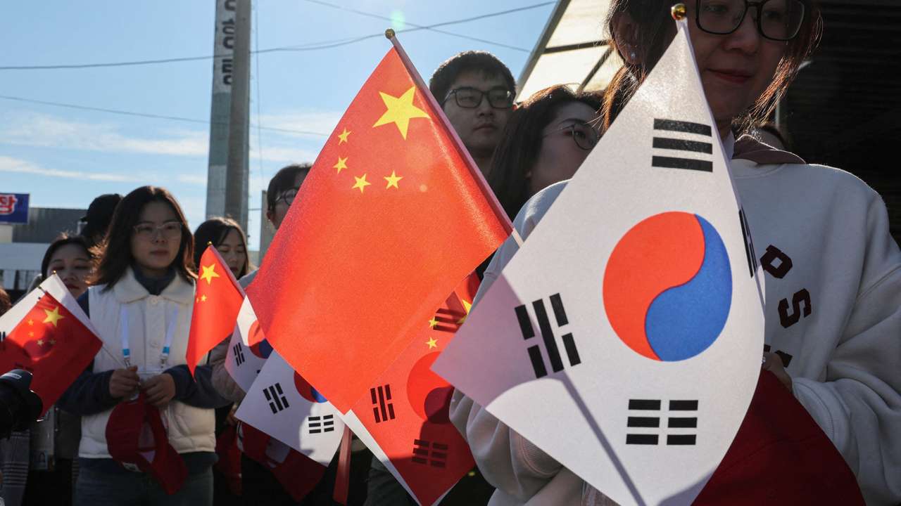 FILE PHOTO: Pro-China supporters hold China and South Korea flags near Gimhae International Airport in Busan