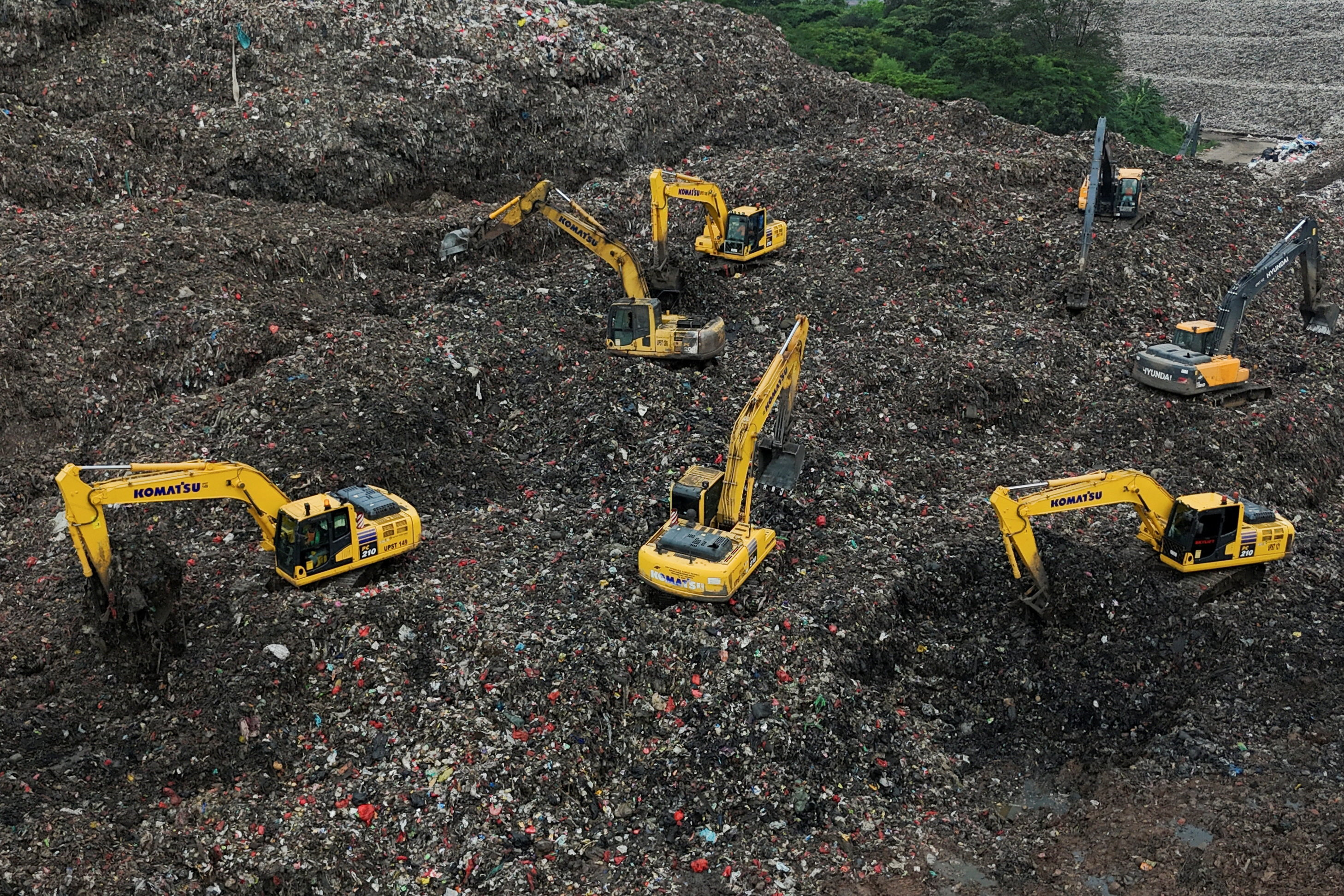 A drone view shows excavators operating amid garbage at the site of collapse at the Bantar Gebang landfill during a rescue operation in Bekasi