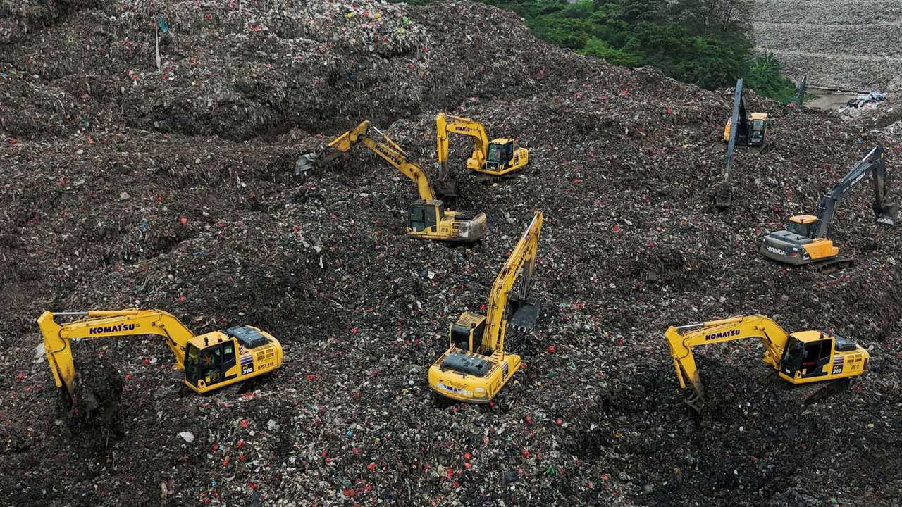 A drone view shows excavators operating amid garbage at the site of collapse at the Bantar Gebang landfill during a rescue operation in Bekasi