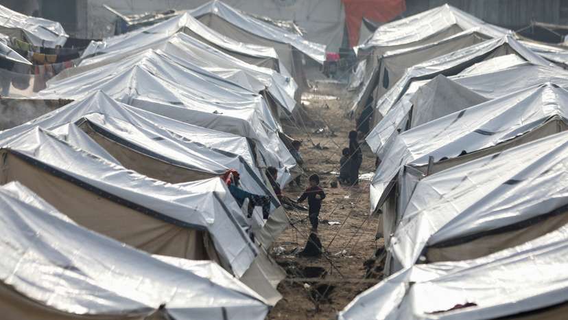 Displaced Palestinians fix their tents following rainfall, in Gaza City