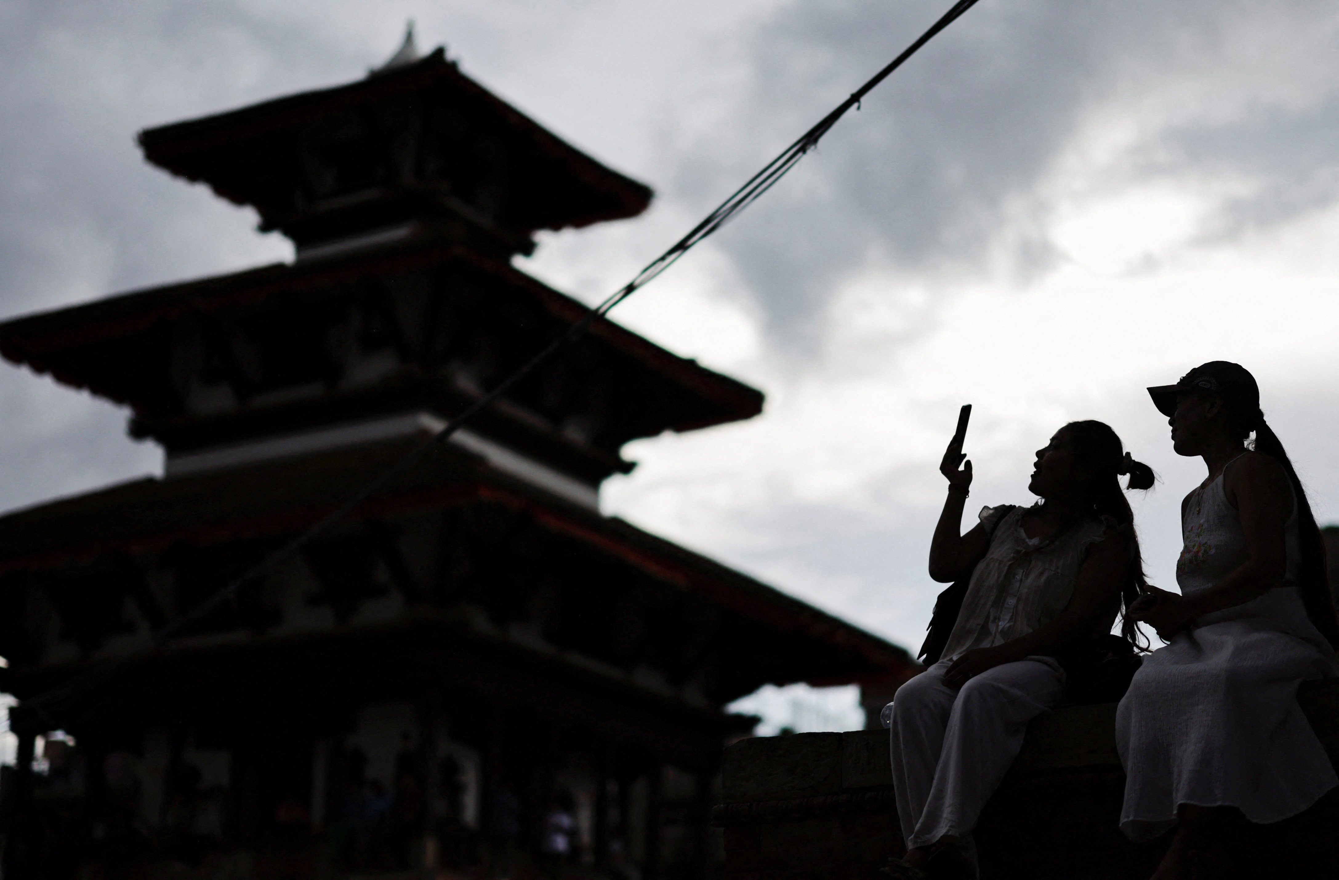 A woman uses her phone at Bashantapur Durbar Square after the government announced it will close all social media not registered with the government saying the move was aimed at managing and Making the social media responsible in Kathmandu