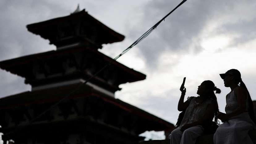 A woman uses her phone at Bashantapur Durbar Square after the government announced it will close all social media not registered with the government saying the move was aimed at managing and Making the social media responsible in Kathmandu