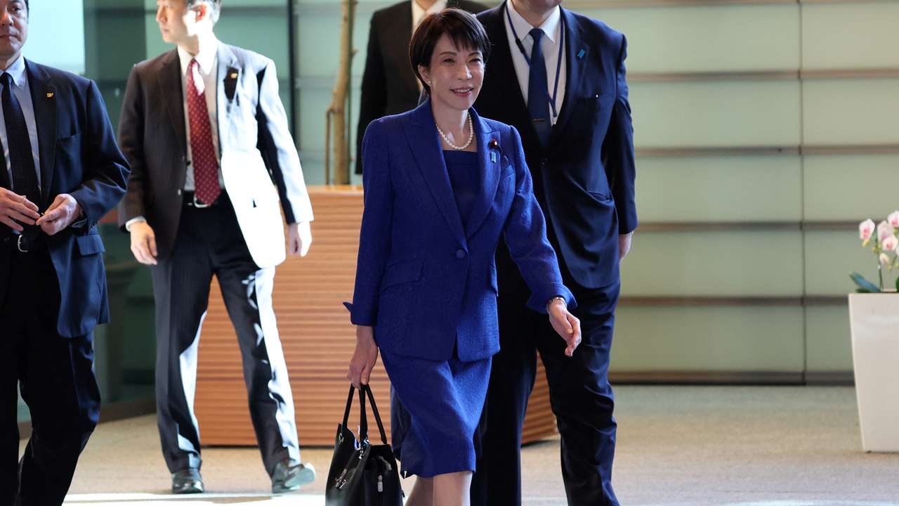Japan's Prime Minister Sanae Takaichi carries Japanese leather goods maker Hamano’s tote bag as she arrives at the Prime Minister's Office in Tokyo