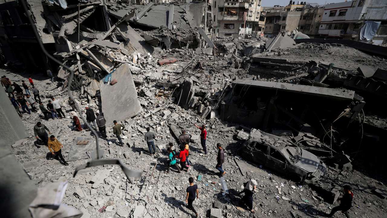 Palestinians inspect the site of an Israeli strike on a residential building in Jabalia