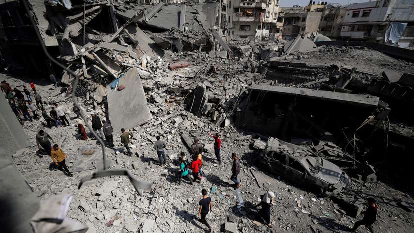 Palestinians inspect the site of an Israeli strike on a residential building in Jabalia