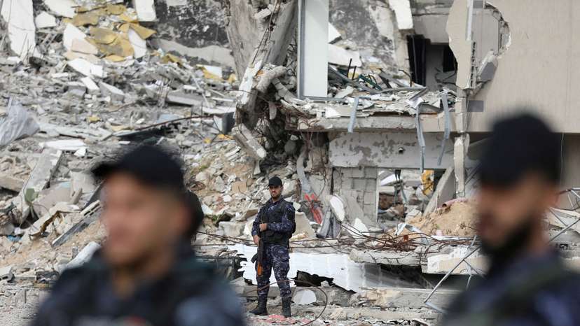 Palestinian Hamas policemen keep guard at their destroyed headquarters in Gaza City