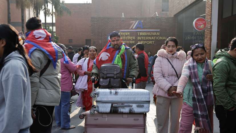 Ramesh Bahadur B.K. Nimaile is followed by his weeping mother Dudkala Nimaile and wife Meena Nimale, as he heads towards the departure terminal for a job in Romania, at Tribhuvan International Airport