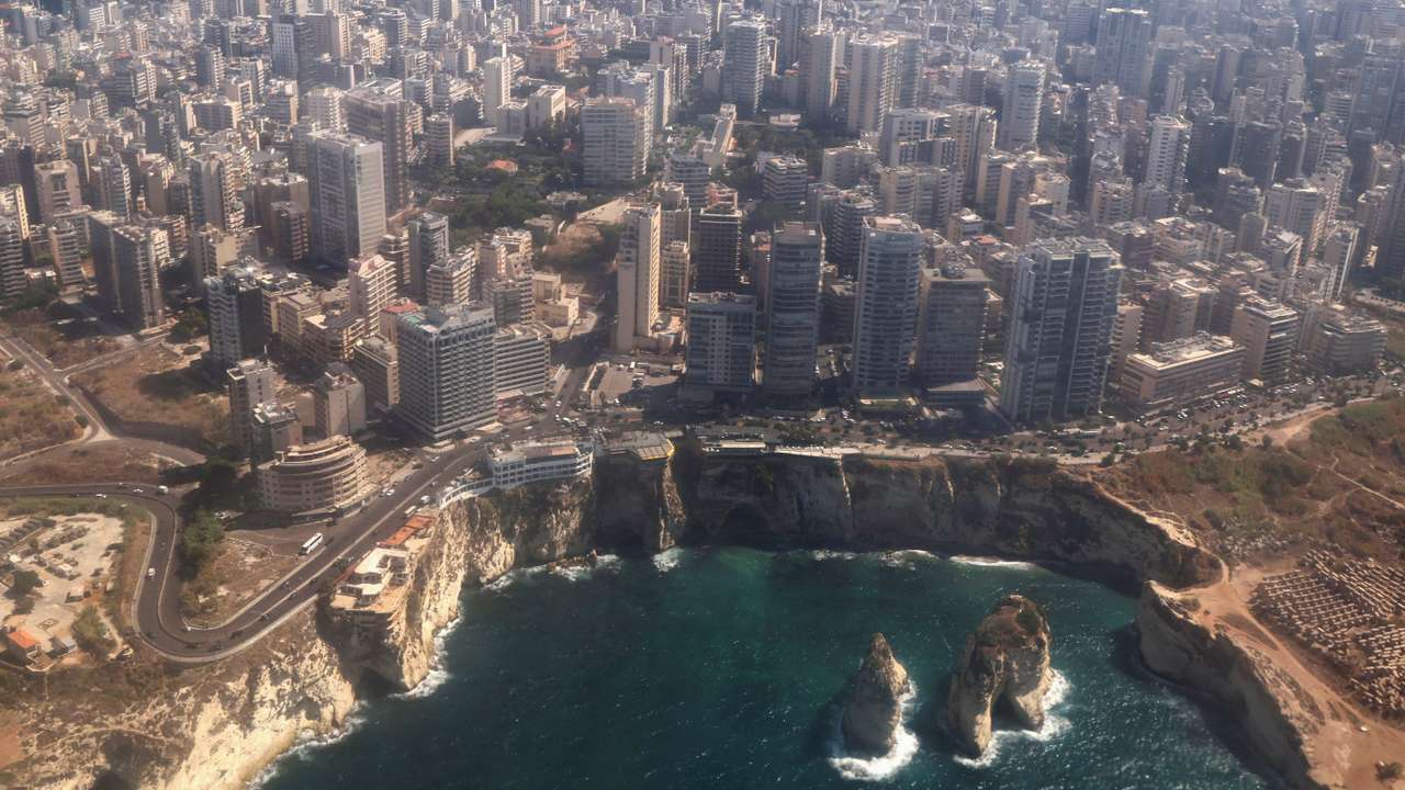An aerial view from an airplane window shows the coast and the Raouche Rock with a general view of the Lebanese capital Beirut