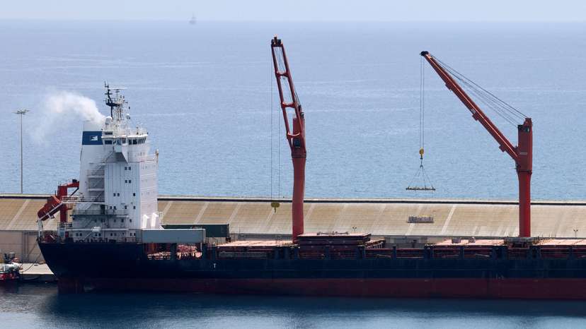 FILE PHOTO: A crane lifts material onto a cargo vessel expected to take aid to Gaza from Cyprus, at the port of Larnaca