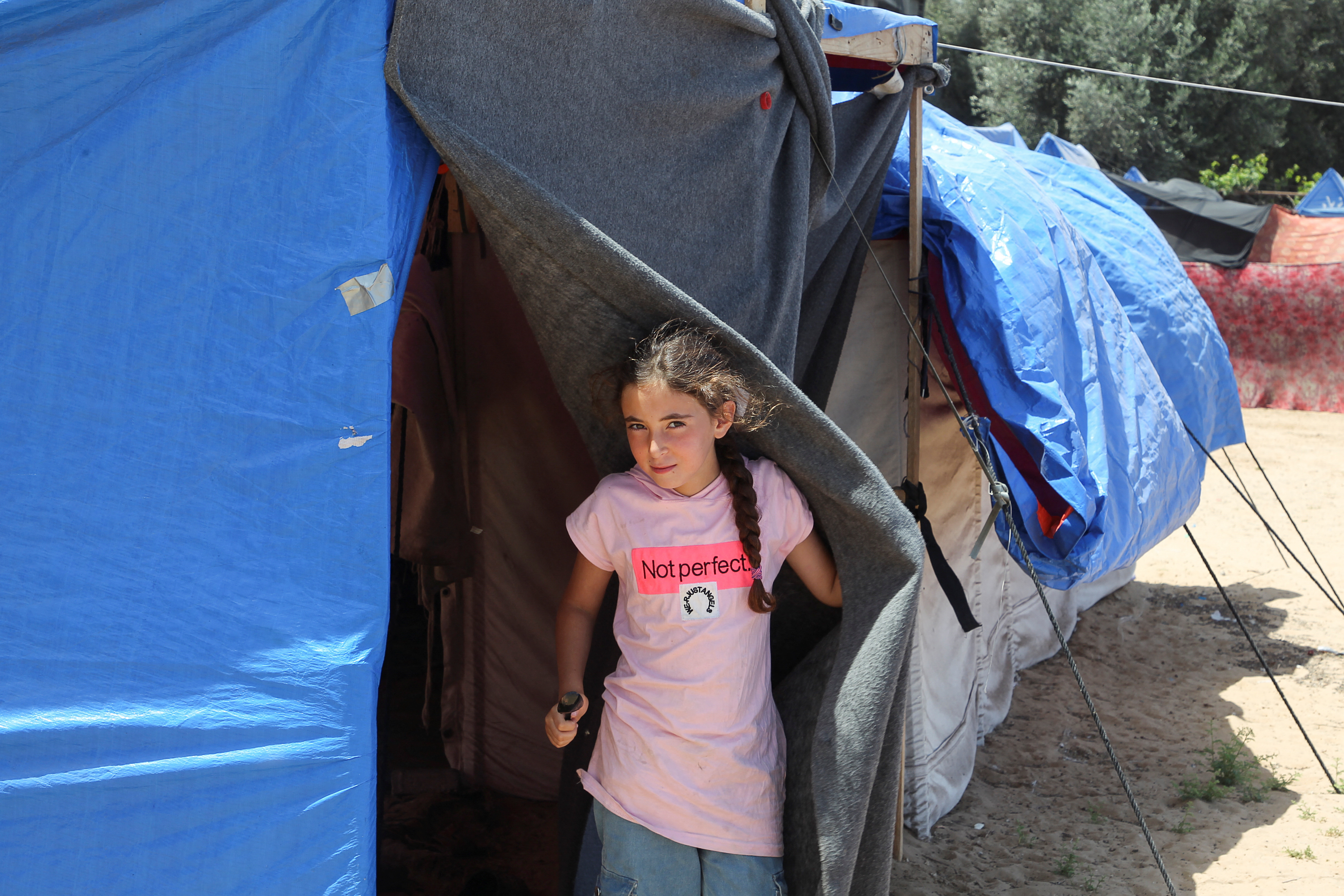 Displaced Palestinians, who fled their houses due to Israeli strikes, shelter at a tent camp in Rafah