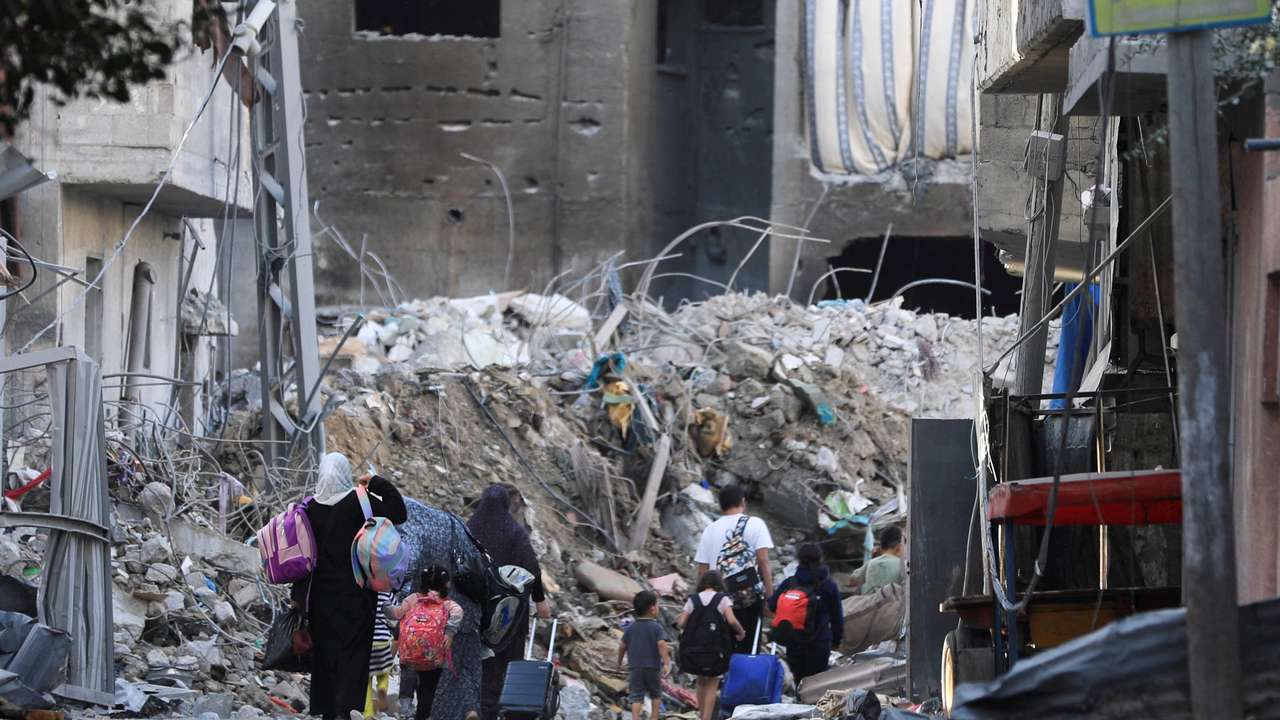 Palestinians carry their belongings as they flee their houses