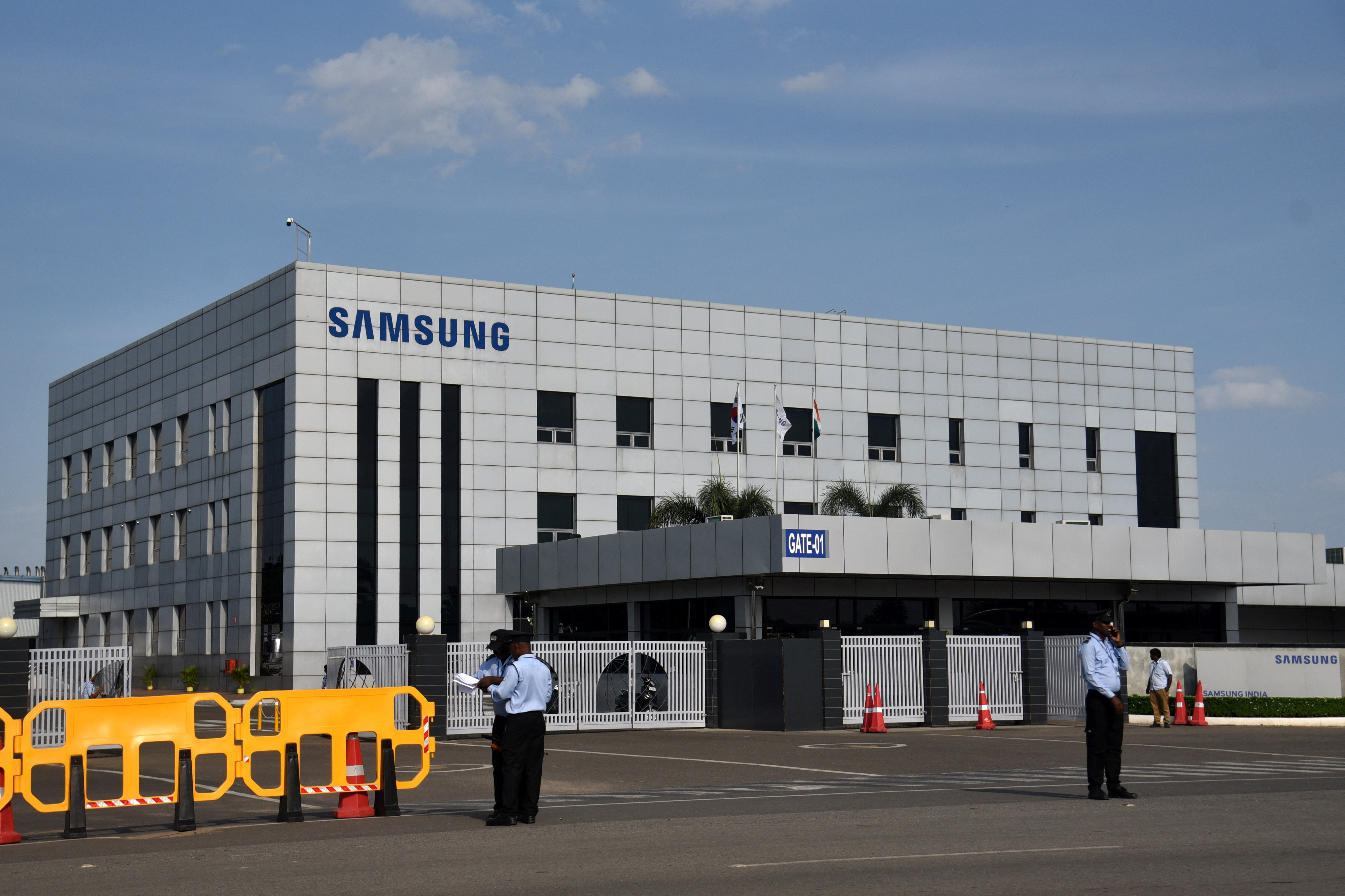 Security guards stand outside a Samsung facility during a strike by the factory workers demanding higher wages in Sriperumbudur