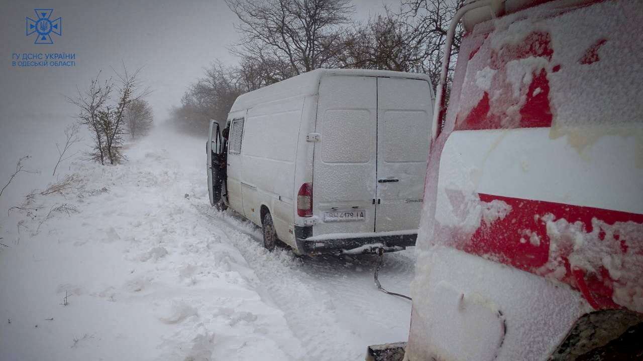 Emergency workers release a van which is stuck in snow during a heavy snow storm in Odesa region