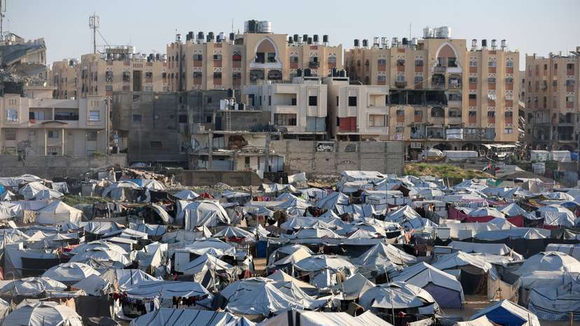 Palestinians displaced during the two-year Israeli offensive shelter at a tent camp in Khan Younis