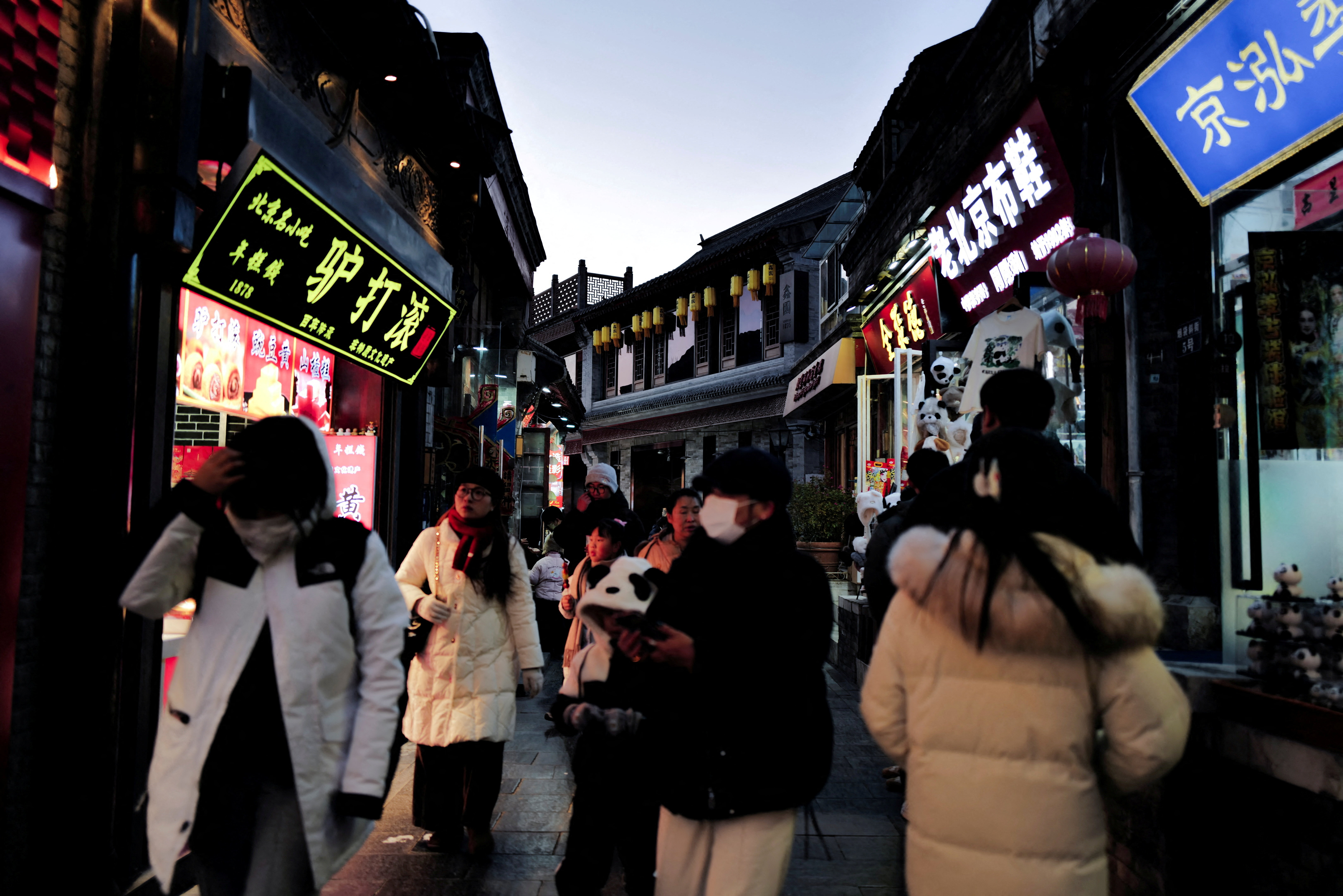 People walk in a commercial street at historical Shichahai district in Beijing