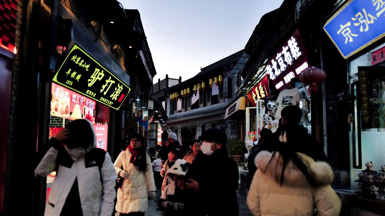 People walk in a commercial street at historical Shichahai district in Beijing