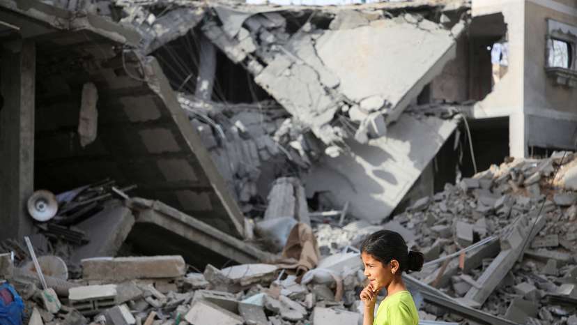 Palestinians inspect the site of an Israeli strike on a house in Rafah