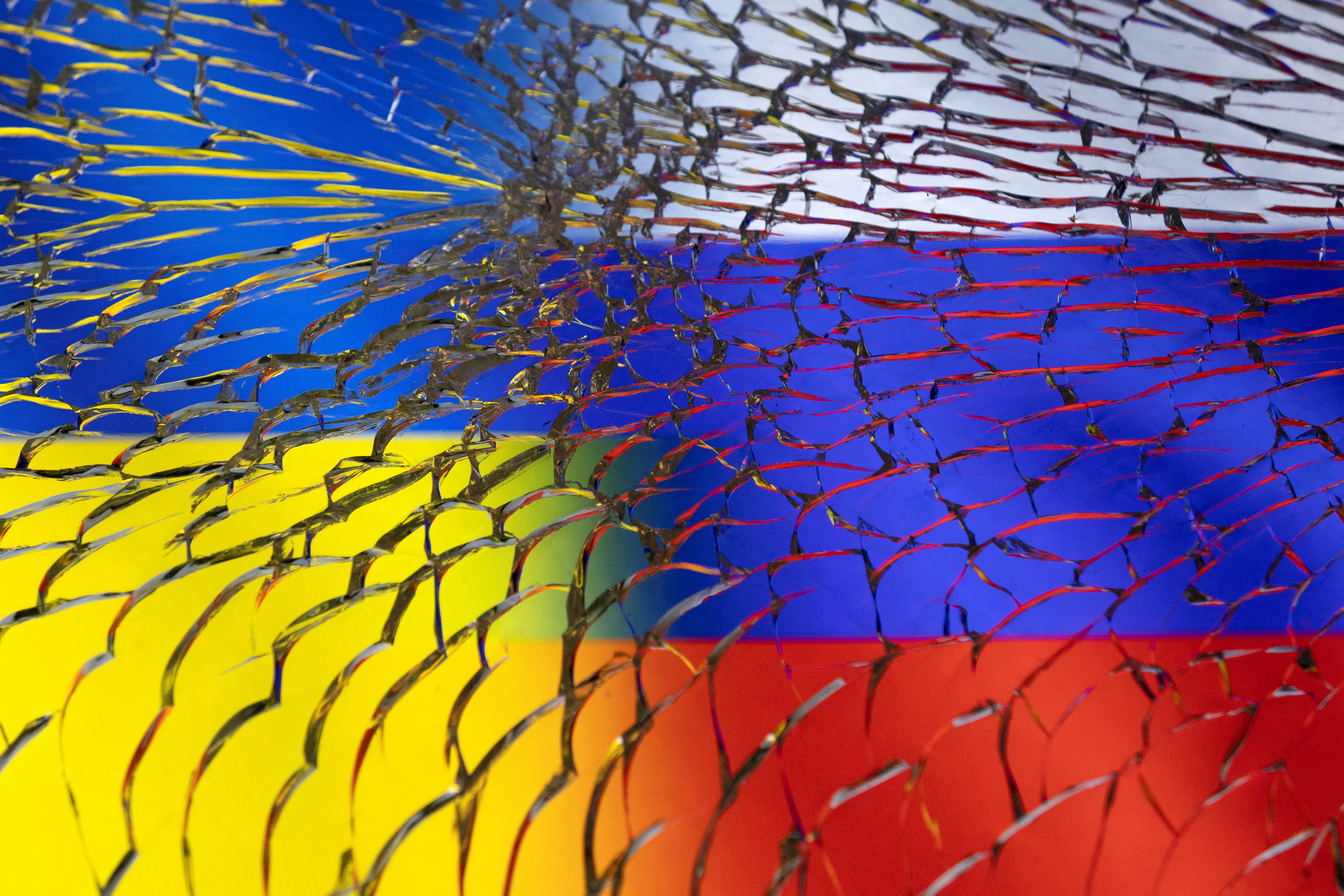 FILE PHOTO: Illustration shows Ukraine and Russian flags through broken glass