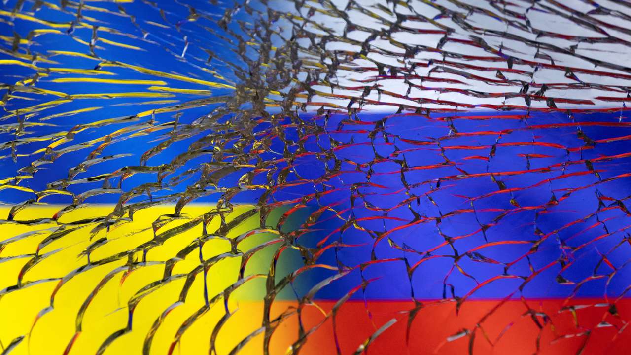 FILE PHOTO: Illustration shows Ukraine and Russian flags through broken glass