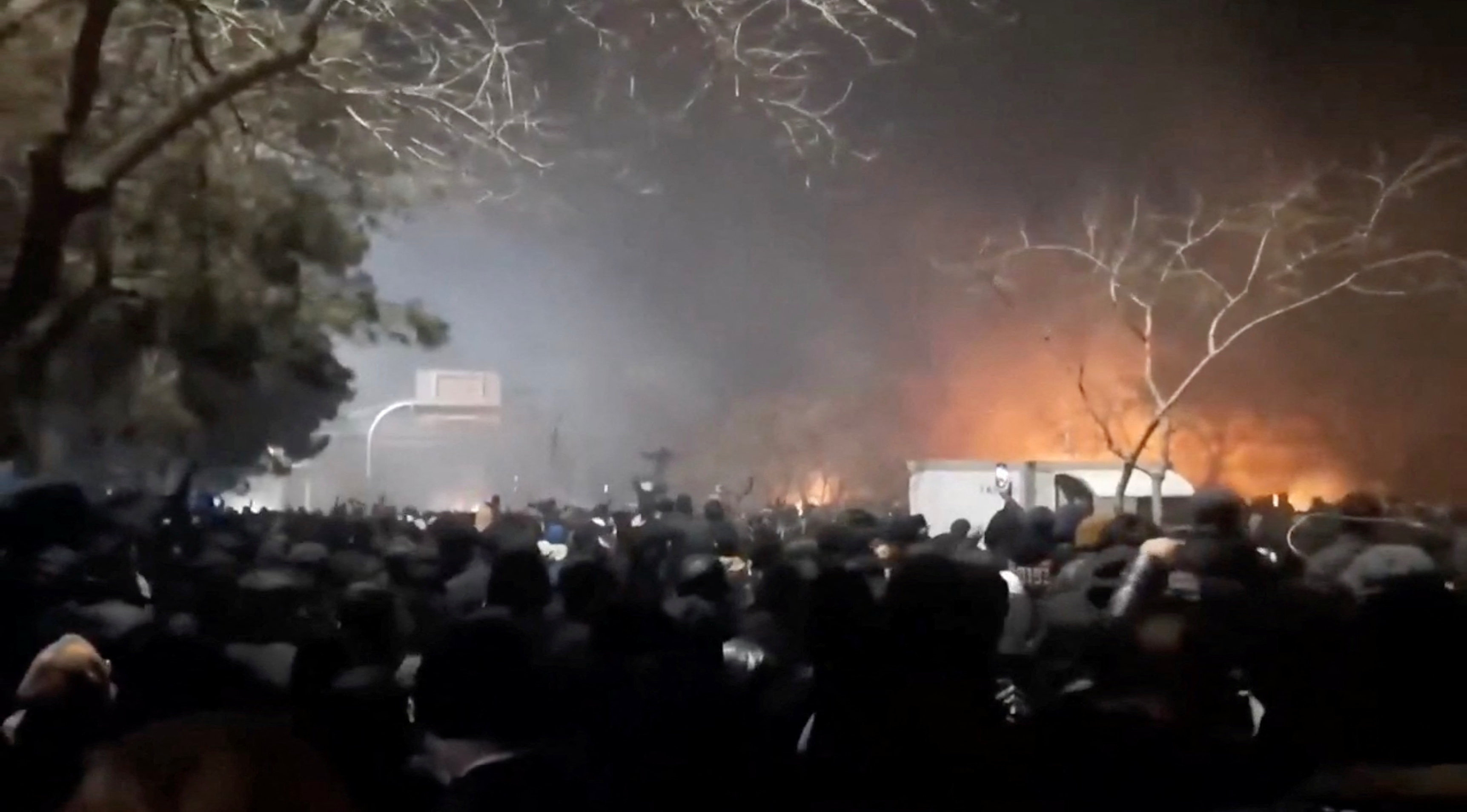Smoke rises as protesters gather amid evolving anti-government unrest at Vakilabad highway in Mashhad