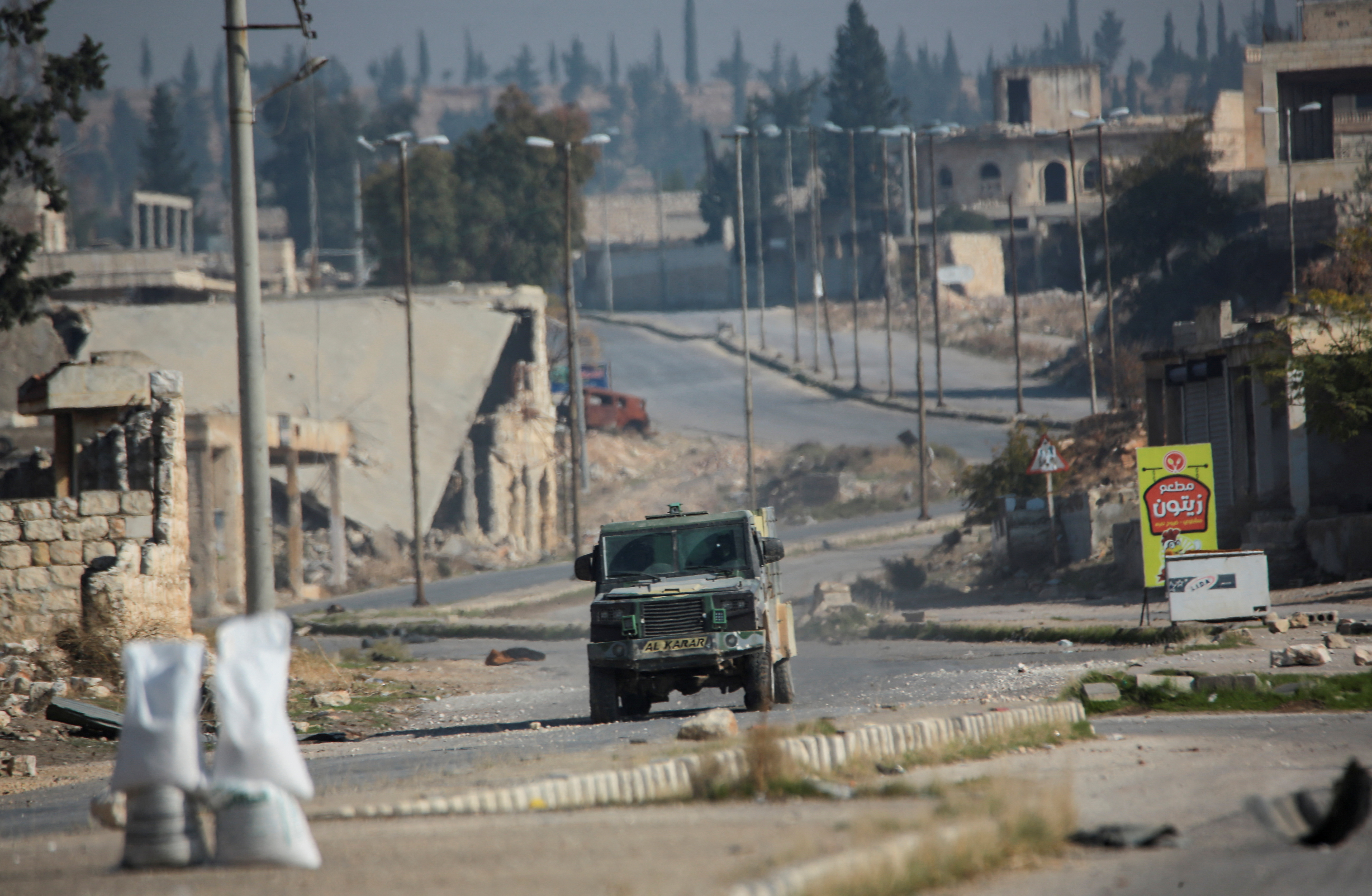 Rebels led by the Islamist militant group Hayat Tahrir al-Sham drive along a street in al-Rashideen, Aleppo province