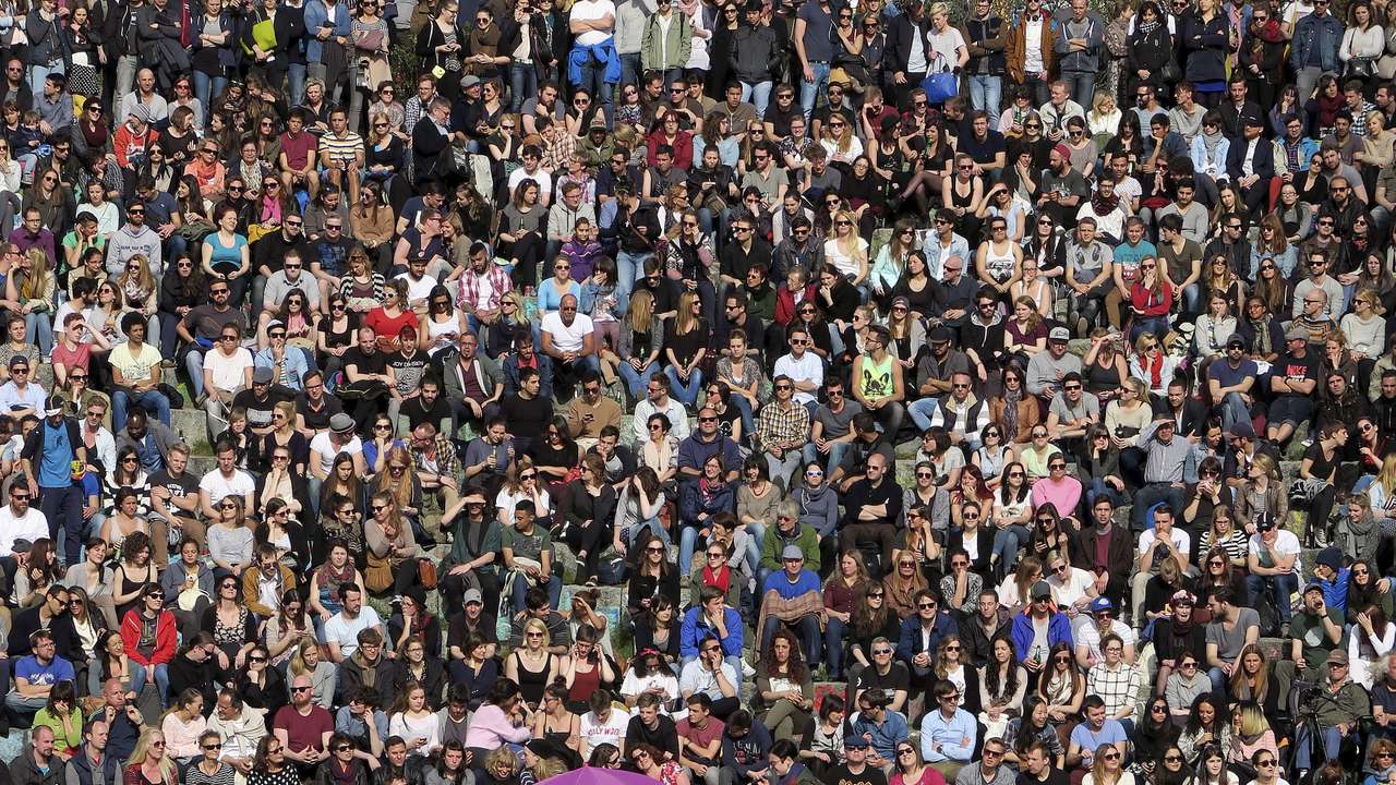 People gather as an artist performs at the Mauer Park in Berlin