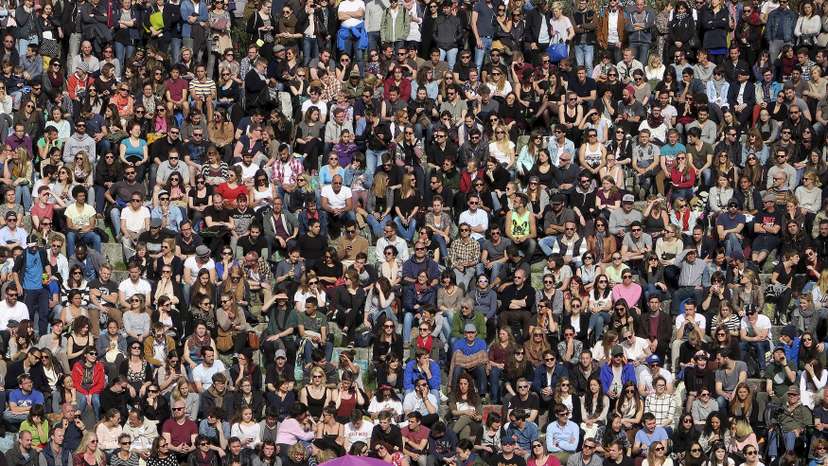 People gather as an artist performs at the Mauer Park in Berlin