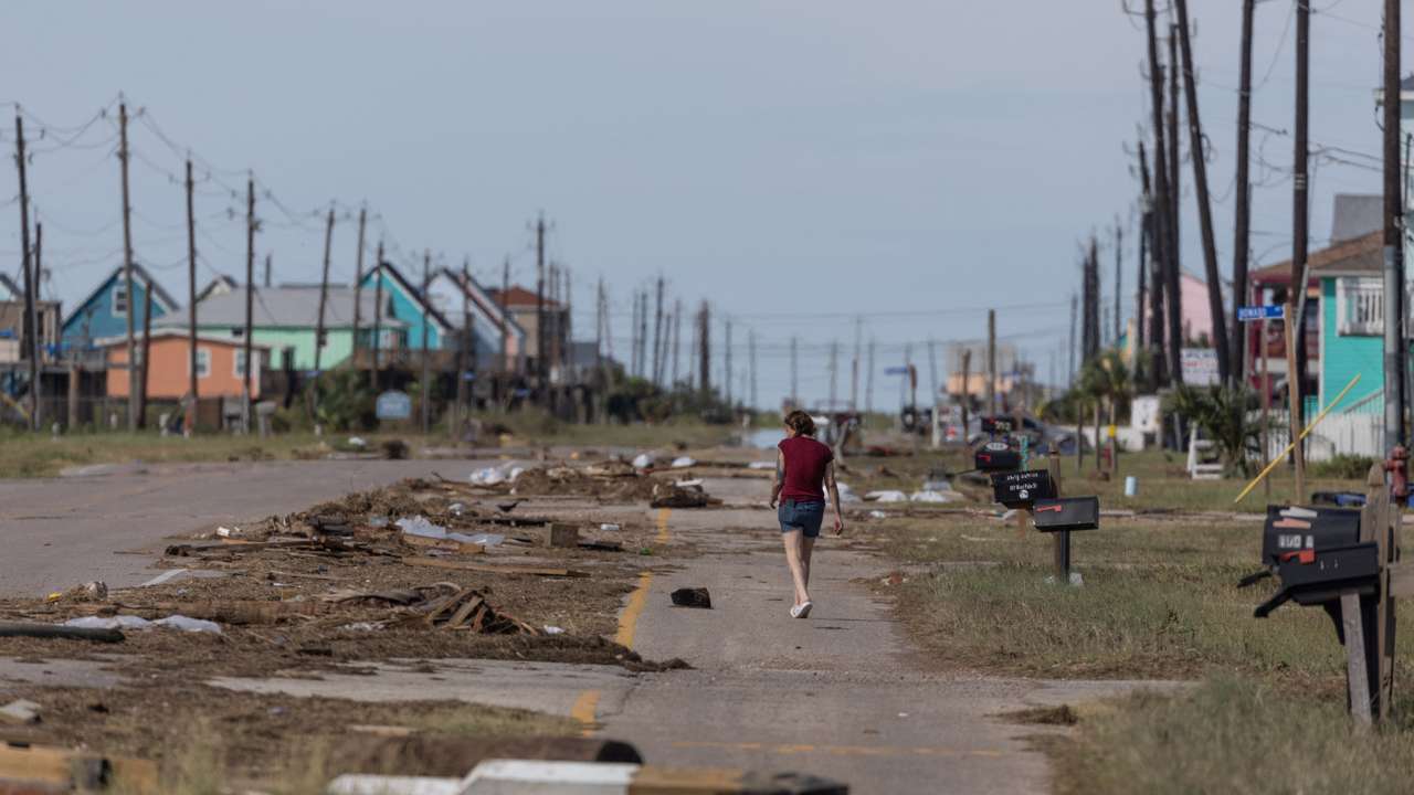Resident walks past debris in the aftermath of Hurricane Beryl in Surfside Beach, Texas