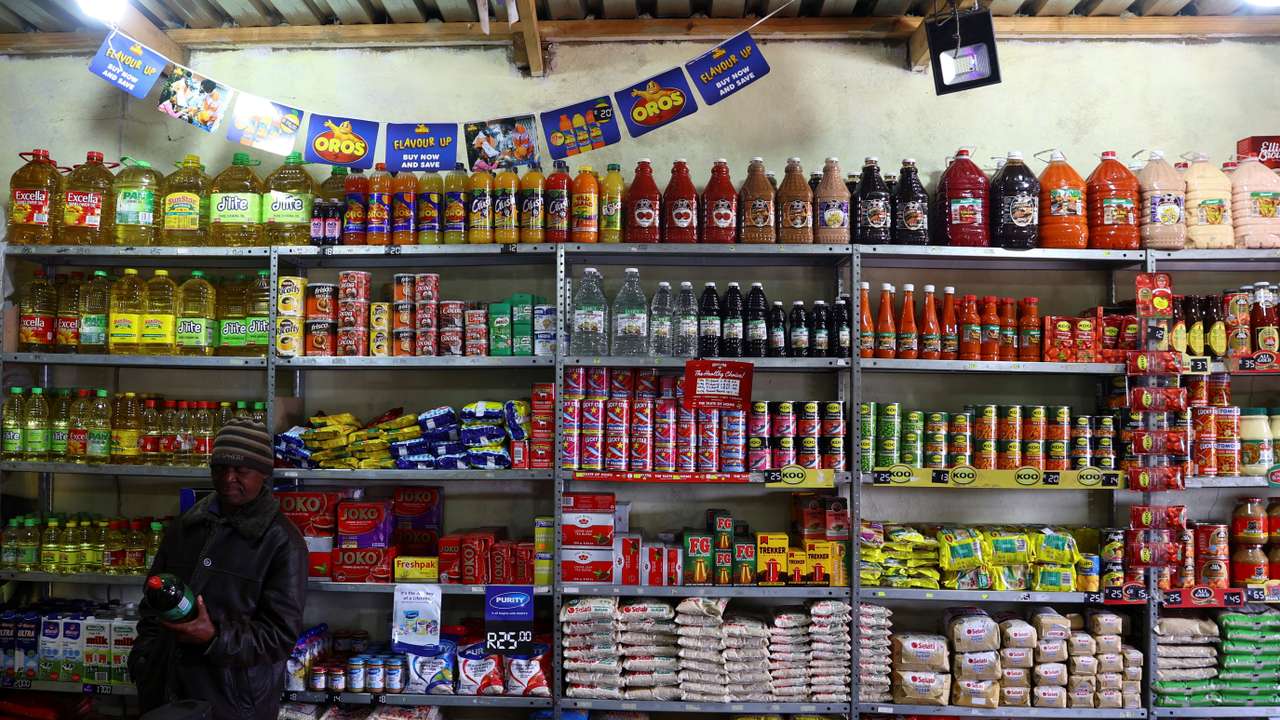 FILE PHOTO: A man looks at an item before buying at a spaza shop