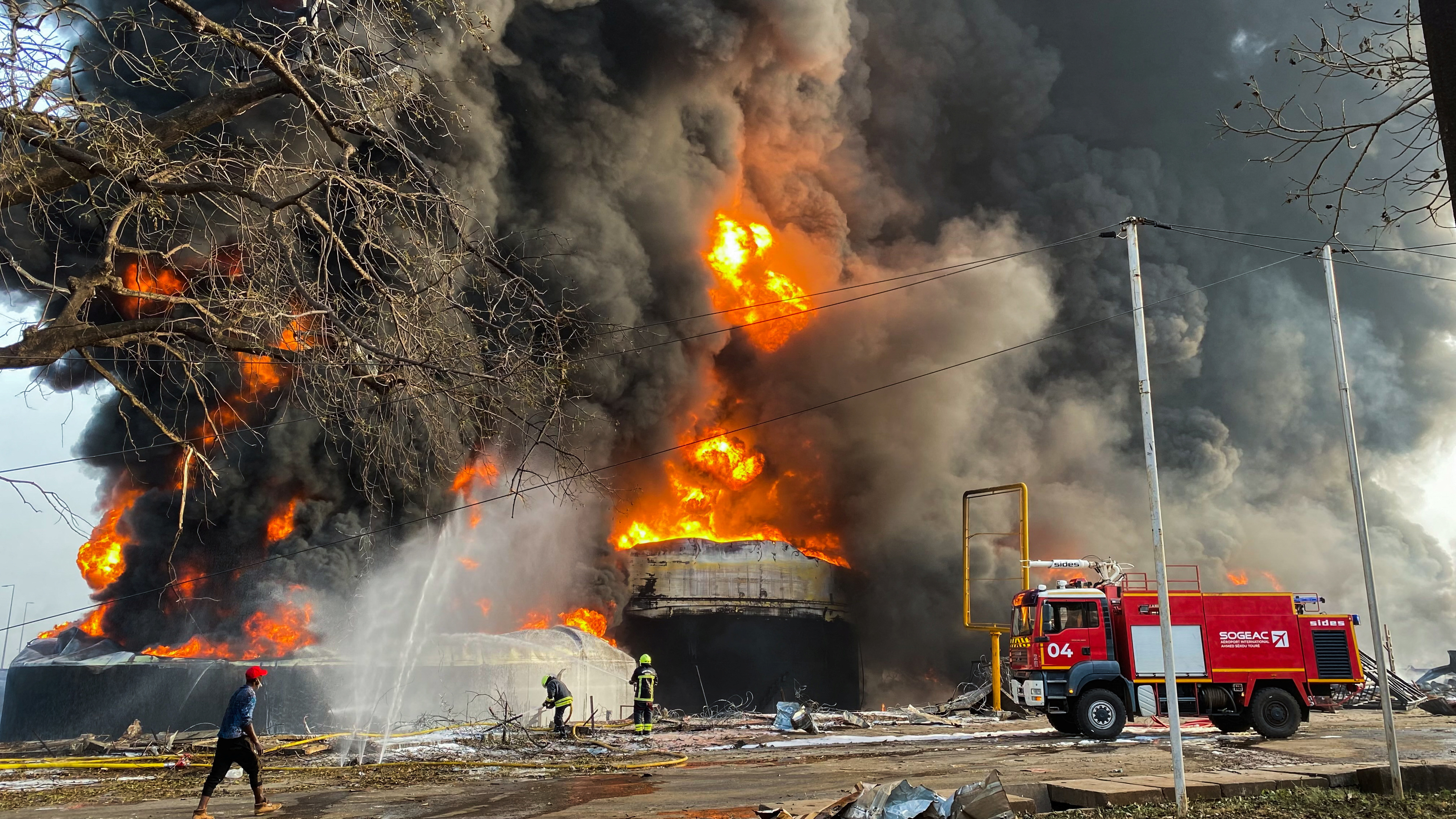 Firemen work to extinguish fire after a blast at an oil terminal in Conakry